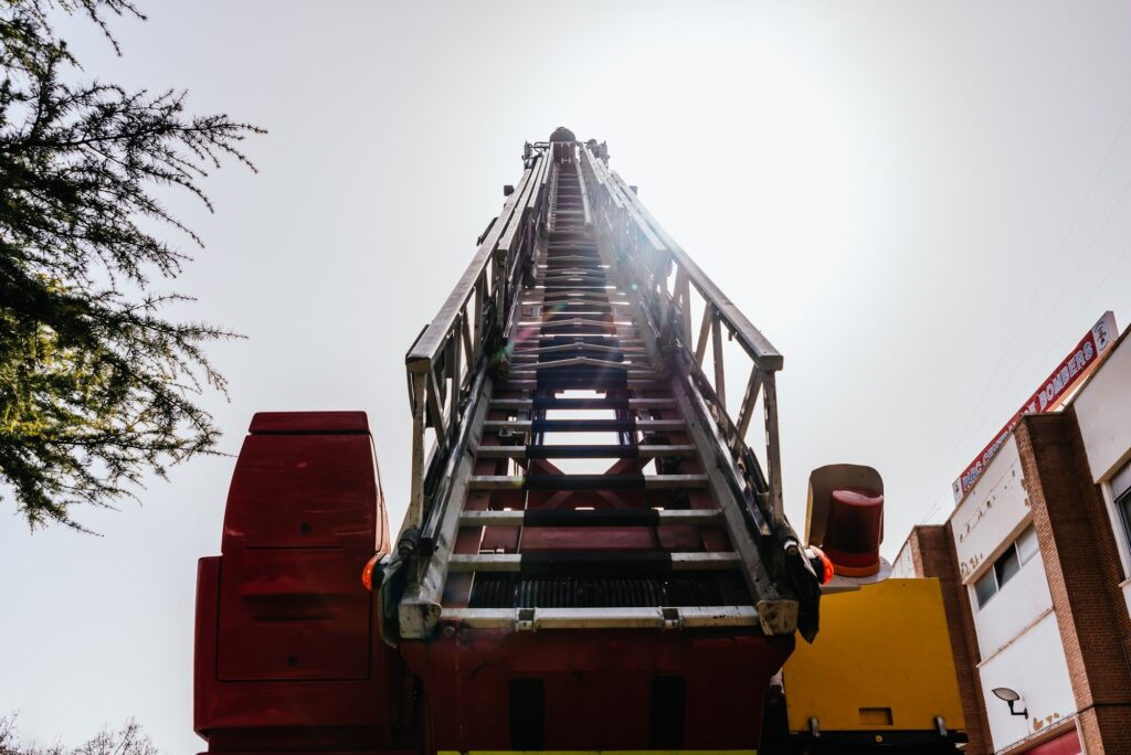 Firemen at the top of the truck ladder performing an emergency.